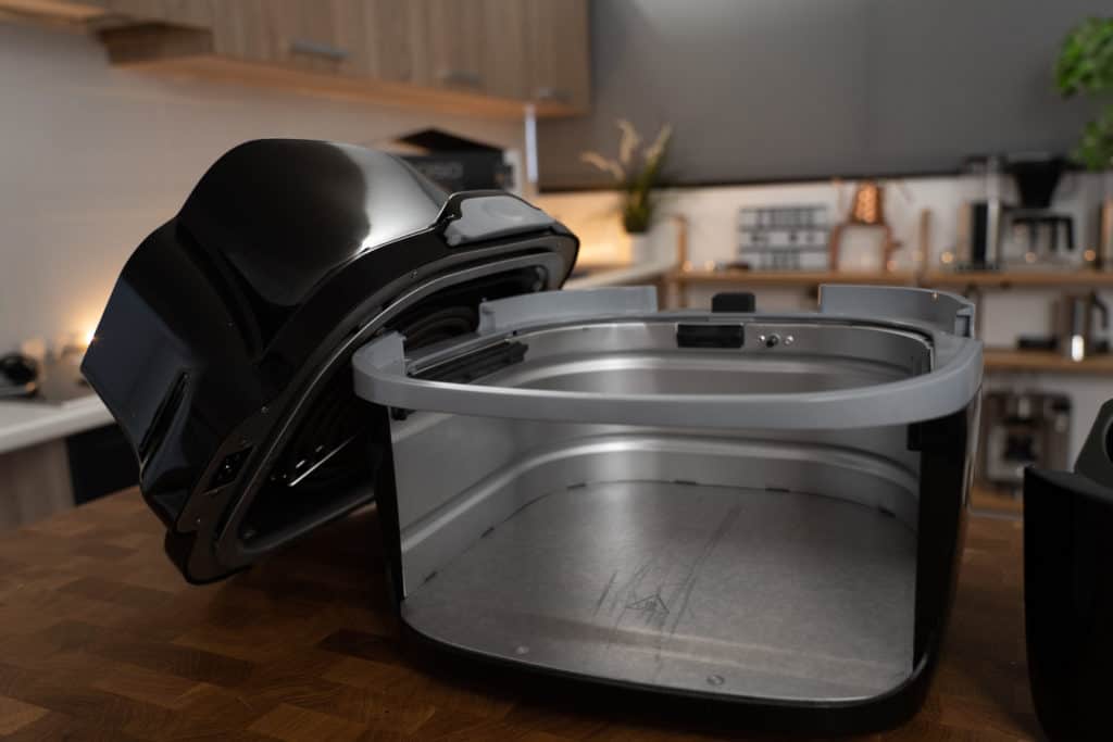 Caso Design AF 400 Heißluftfritteuse - zu sehen ist der untere Teil des Geräts mit dem oberen Teil des Airfryers links davon an das Unterteil schräg angelegt