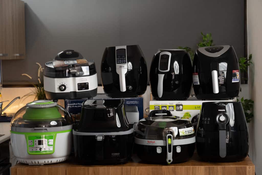 Gruppenbild mit den getesteten Heißluftfritteusen, acht von zehn Geräten (es fehlen die Gourmetmaxx Heißluftfritteuse und Tefal ActiFry Genius XL)