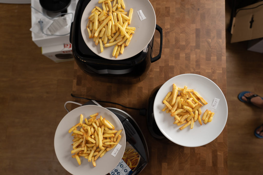 Pommes-Ergebnisse: drei Teller mit fertig zubereiteten Pommes aus verschiedenen Airfryern aus der Vogelperspektive